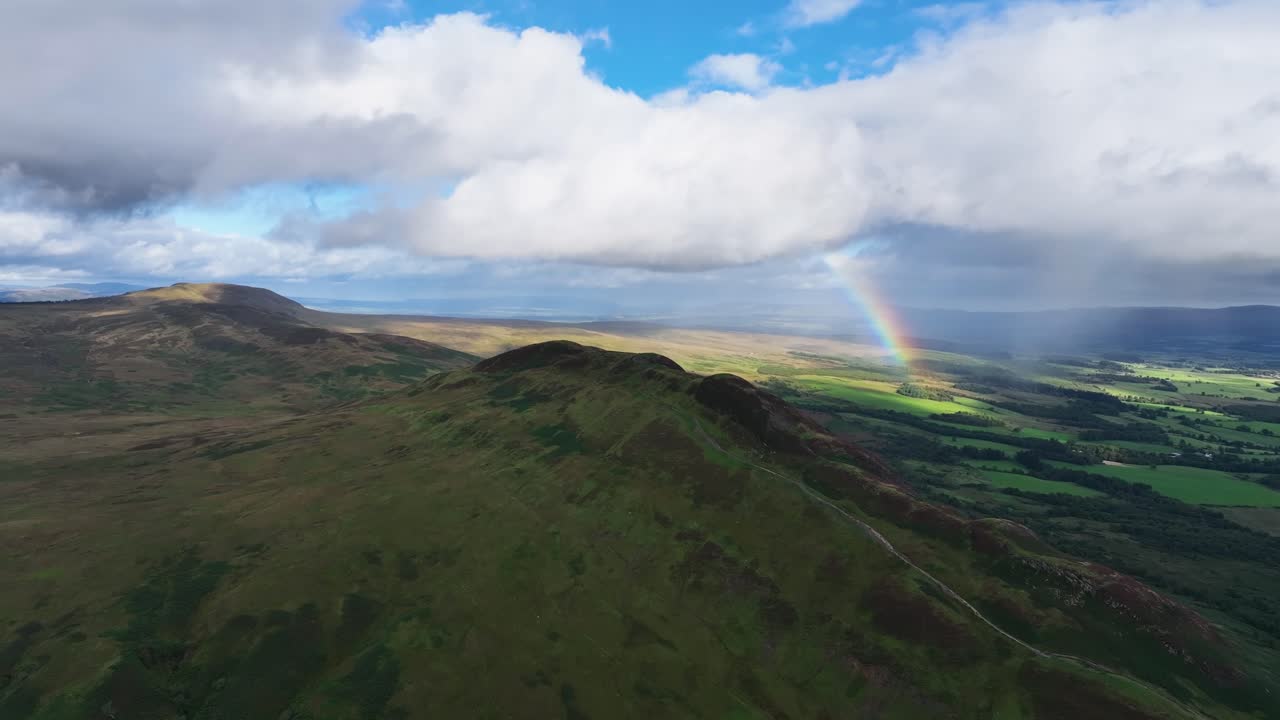 vista aérea de la colina cónica con arco iris en el fondo