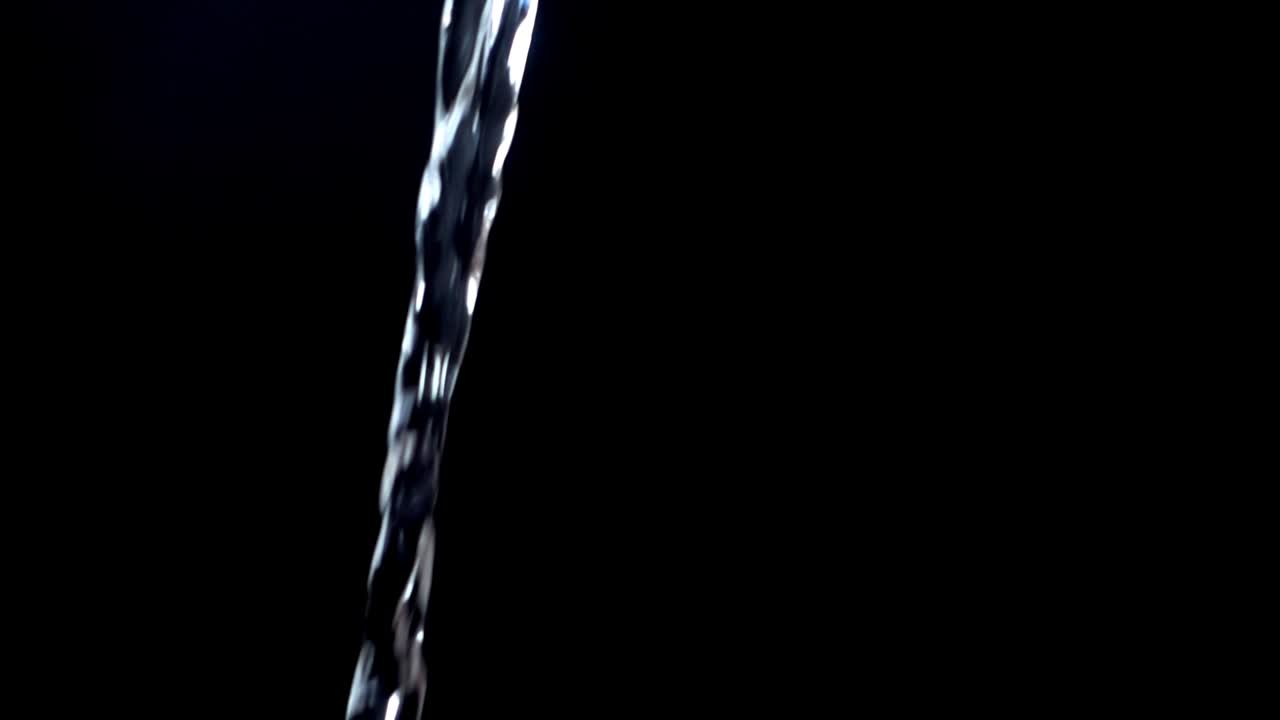 Acqua su sfondo nero. Slow motion.