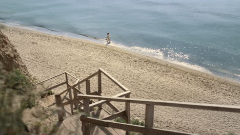 Mujer-Caminando-Con-Vistas-A-Las-Olas-Del-Mar-A-Distancia.-Niña-Remojando-Los-Pies-En-Agua-Del-Océano.