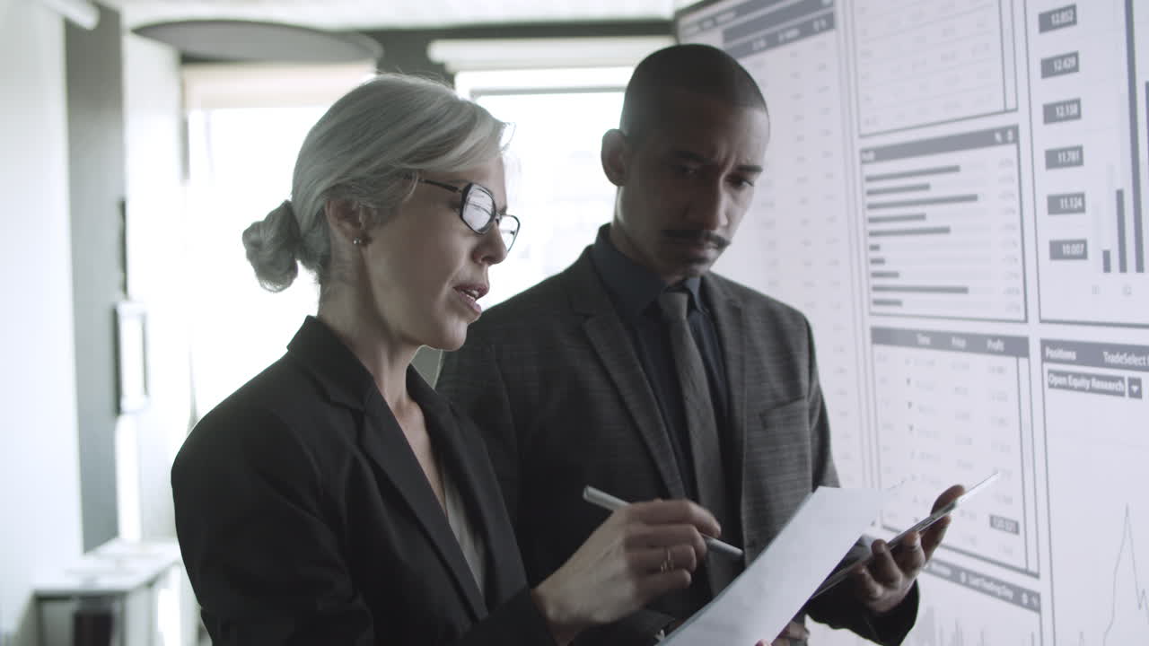 Diverse business colleagues discussing trading graphs