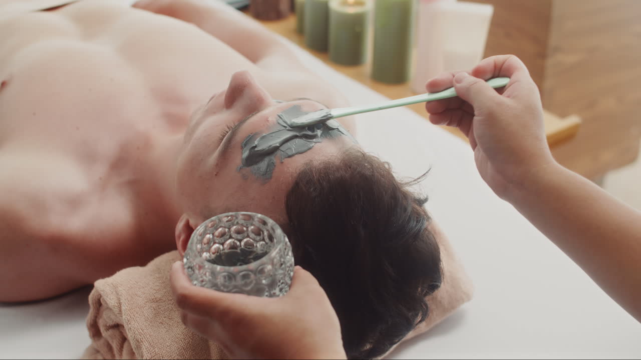 Man Getting Facial Treatment with Clay Mask