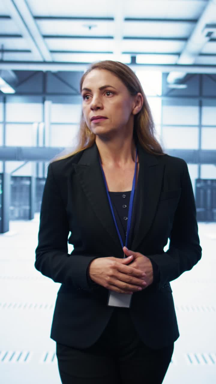 Kvindelig it-professionel står og observerer i et datacenter