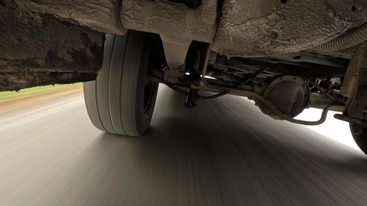 camión conduciendo en la carretera - bajo el eje trasero de una gran furgoneta de entrega - de cerca