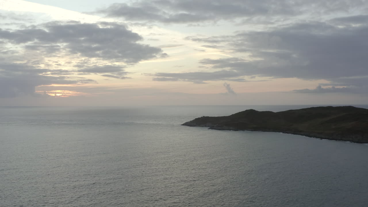 toma aérea ascendente de una hermosa puesta de sol con un promontorio en primer plano