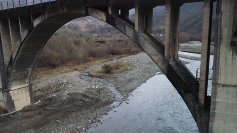 viejo puente de arco de hormigón sobre un río de montaña