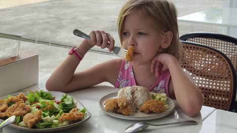 little girl eating lunch at a restaurant