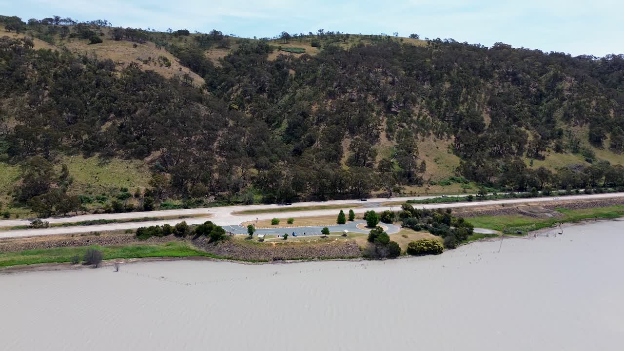 drones paisaje aéreo pan sobre montaña colina carretera carretera federal con coches naturaleza árboles transporte viajes turismo australia río goulburn lago george nsw acto 4k