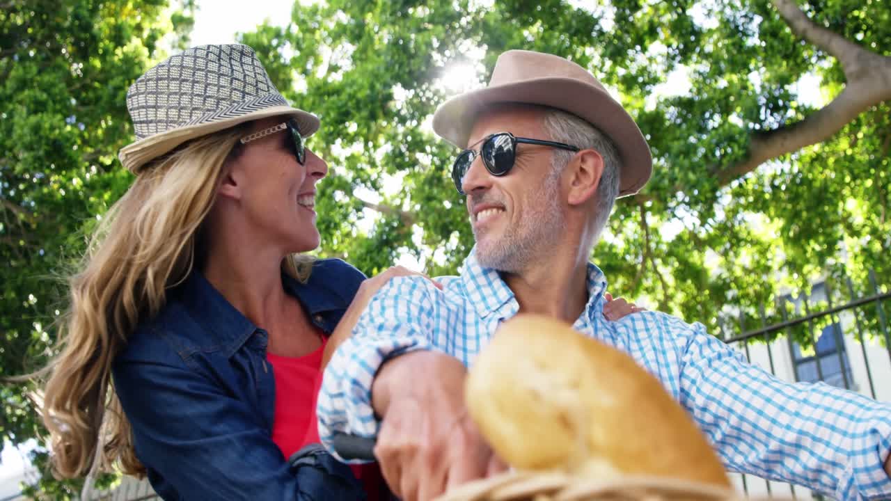 retrato de una pareja madura sonriendo en una bicicleta