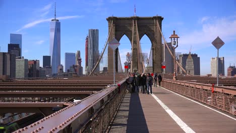 pedestrians cross the brooklyn bridge with manhattan and the freedom tower in the distance 1