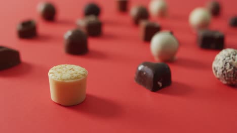 Black and white chocolates on pink background at valentine&#039;s day