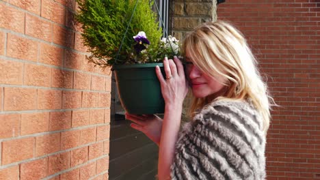 attractive woman enjoying basket of flowers in garden medium zoom in medium shot slow motion portrait