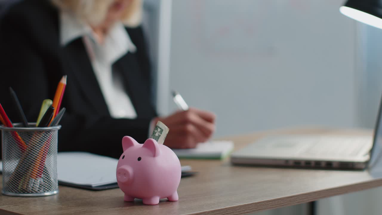 Piggy bank senior business woman accountant typing on laptop computer calculating money income
