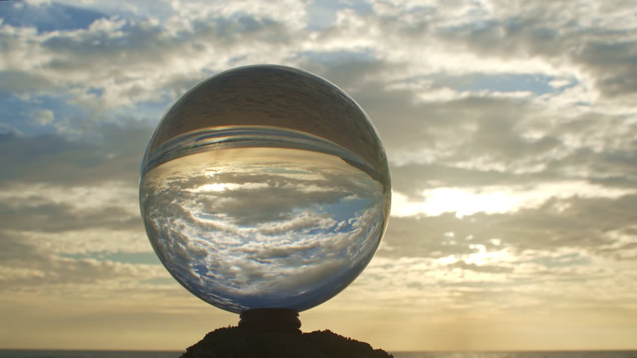 vista mágica del atardecer en la playa en una bola de cristal.