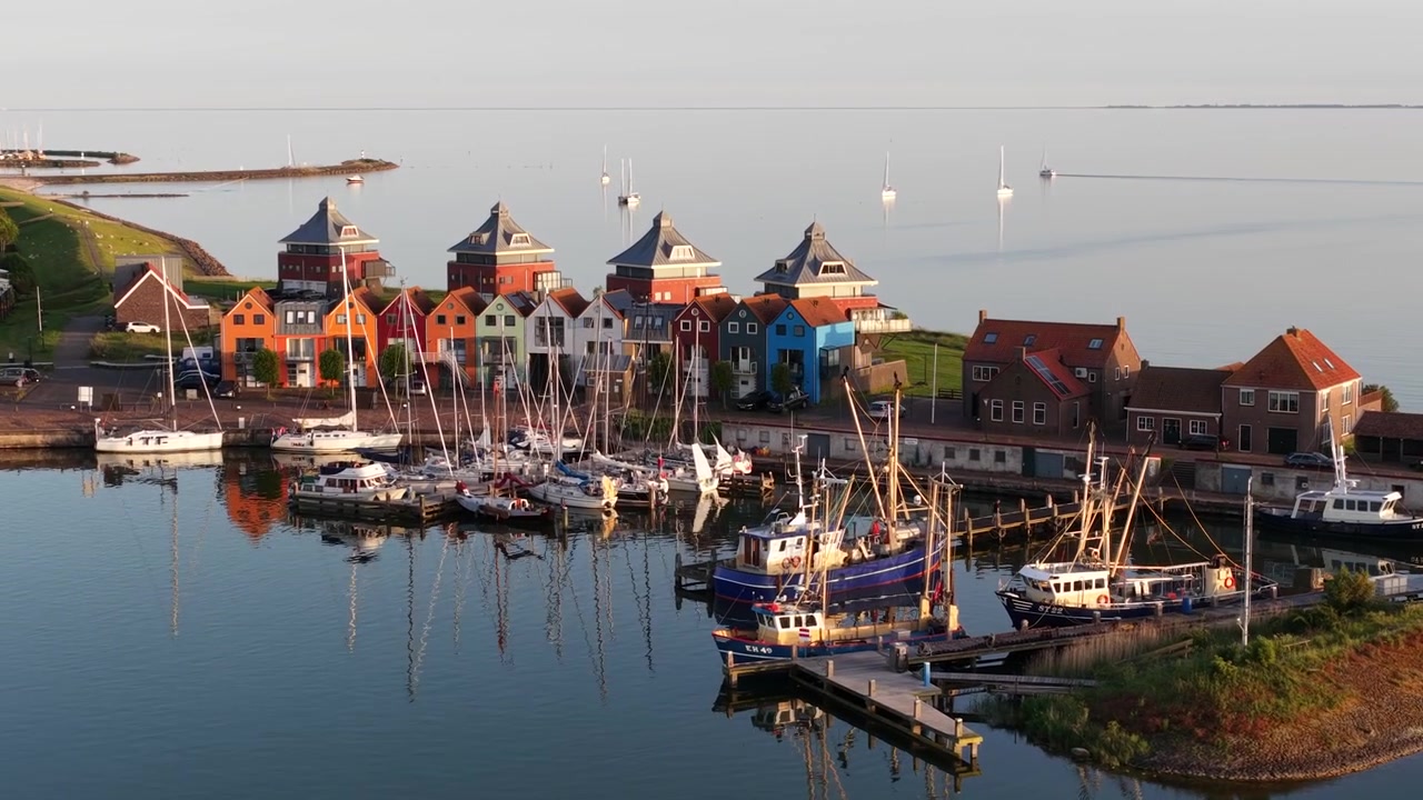 Veduta aerea del lungomare del porto di Stavoren in Frisia, Paesi Bassi, che mostra il porto turistico, le barche e lo storico paesaggio costiero nella calda luce dell'ora d'oro