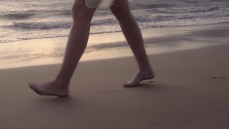 woman walking down a sandy beach at sunset in maui hawaii