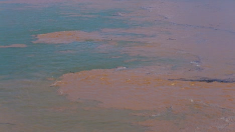 muddy water washing into clean bule aqua river mekong at the start of south east asia monsoon season