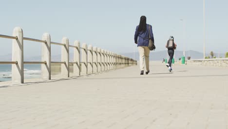 Video-of-back-of-african-american-father-and-son-on-scooter-spending-time-by-sea