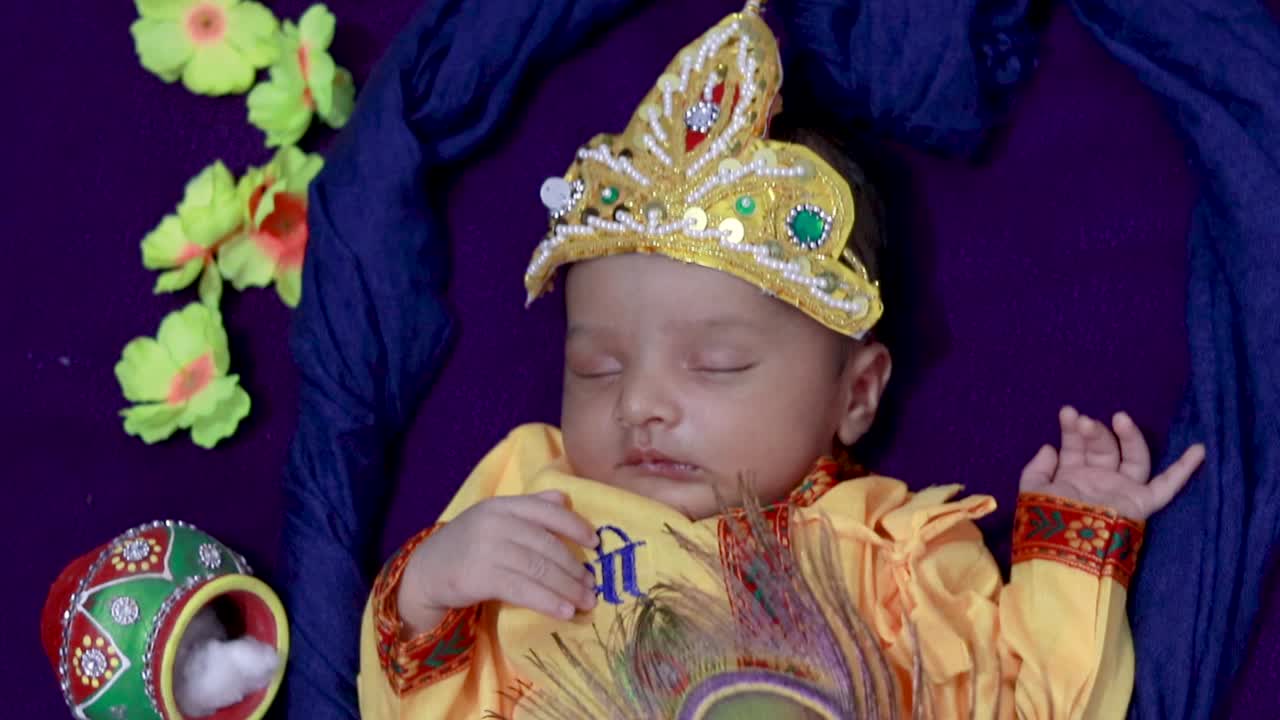 niño recién nacido en Krishna vestido con accesorios desde una perspectiva única en una expresión diferente