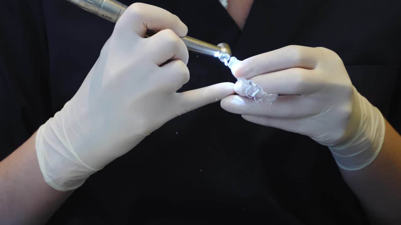Dental professional demonstrating an Invisalign clear aligner, prepared for orthodontic treatment