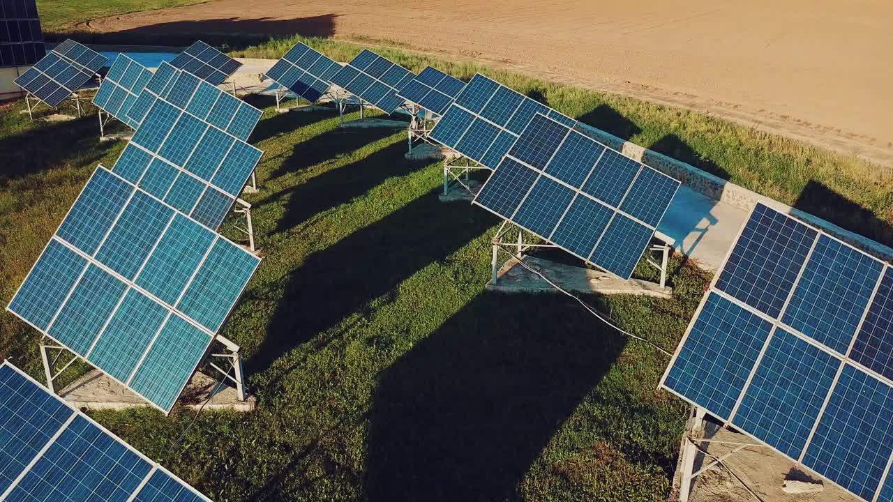 view of two rows of solar panels on the background of green grass. Plant for the production of solar panels. Aerial view. Ecology.