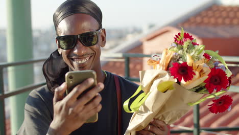 gay having video call with friend and showing flowers from lover