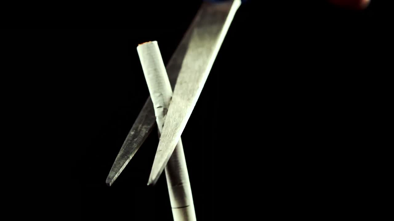 tijeras cortando un cigarrillo por la mitad