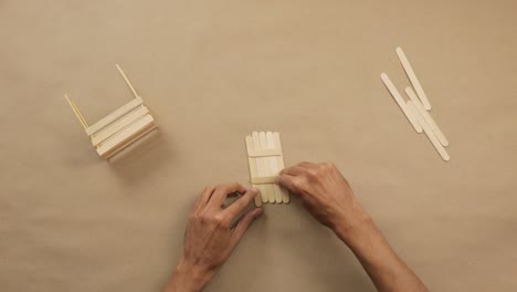 hacer artesanías creativas con palillos de helado, pegándolos juntos