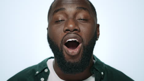 closeup surprised african man looking at camera in light background in studio.