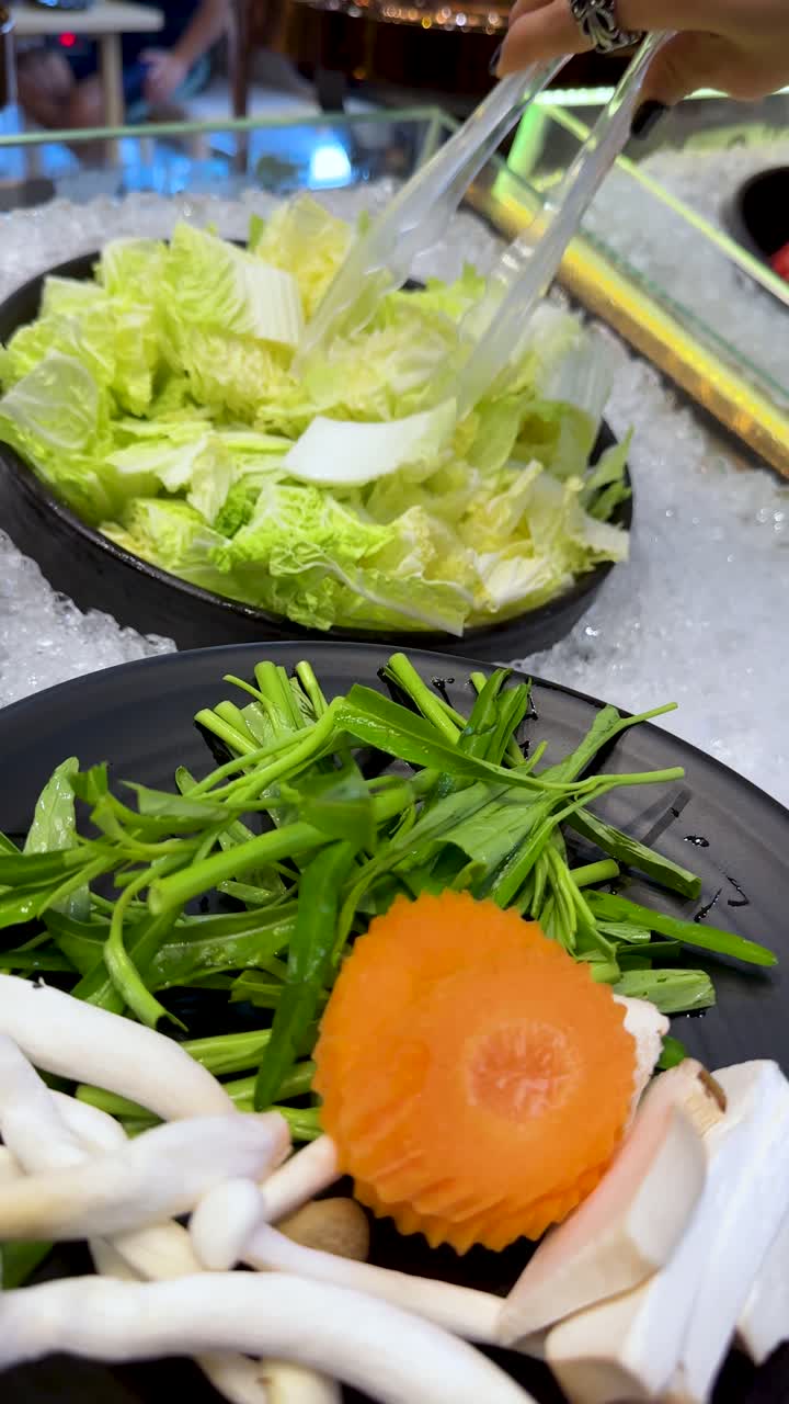ビュッフェで新鮮な野菜とキノコを皿に盛り付ける人