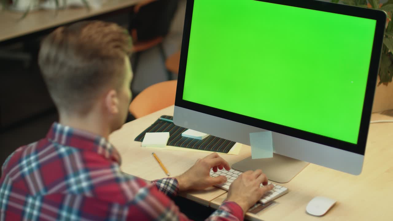 hombre de negocios escribiendo en la computadora con pantalla verde. joven trabajando en la computadora