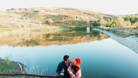 flying over a couple tasting wine on pontoon near a lake