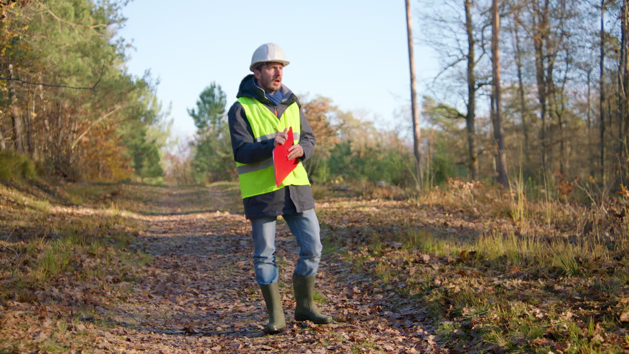 trabajador con ropa de protección, hojas de otoño en el suelo