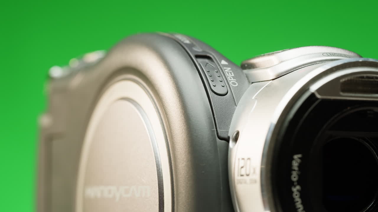 Vintage video-camera with disk inside rotating on green background close-up. Using portable camcorder to shooting videos