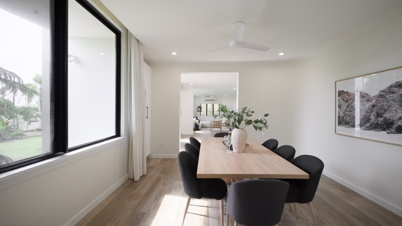 moderno lujo minimalista interior del hogar área de comedor con mesa y sillas conduce a un pequeño salón área de entretenimiento con pisos de madera sofá armario de televisión