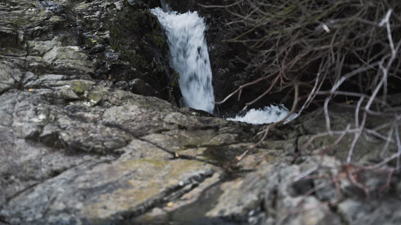 Small waterfall flowing with rocks in foreground