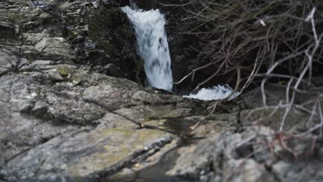 Pequeña-Cascada-Que-Fluye-Con-Rocas-En-Primer-Plano