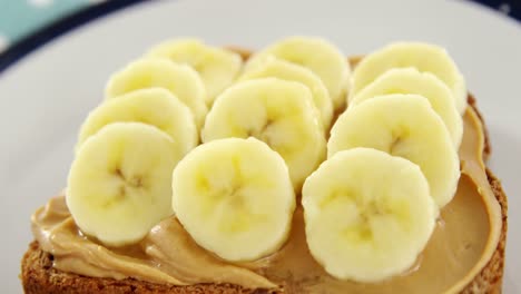 sliced bananas spread on brown bread in plate