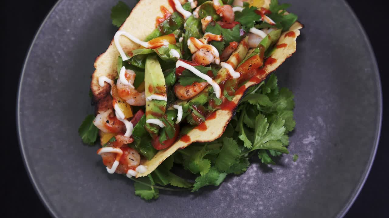 sobrecarga de un taco de camarones recién preparado girando sobre fondo negro, 4k