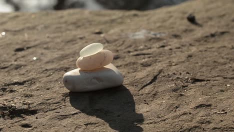 Zen-stones-at-waterfront-with-sun-rays