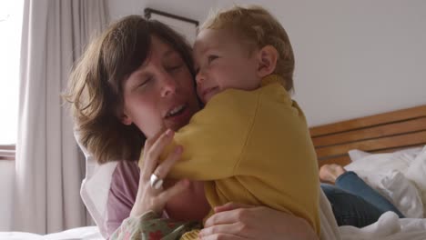 Caucasian-woman-with-her-baby-at-home-in-bedroom