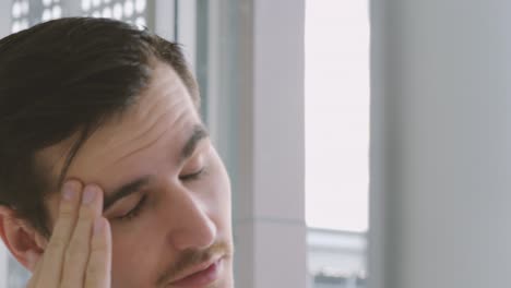 tired and stressed businessman looking at the monitor of a personal computer, working in a home office