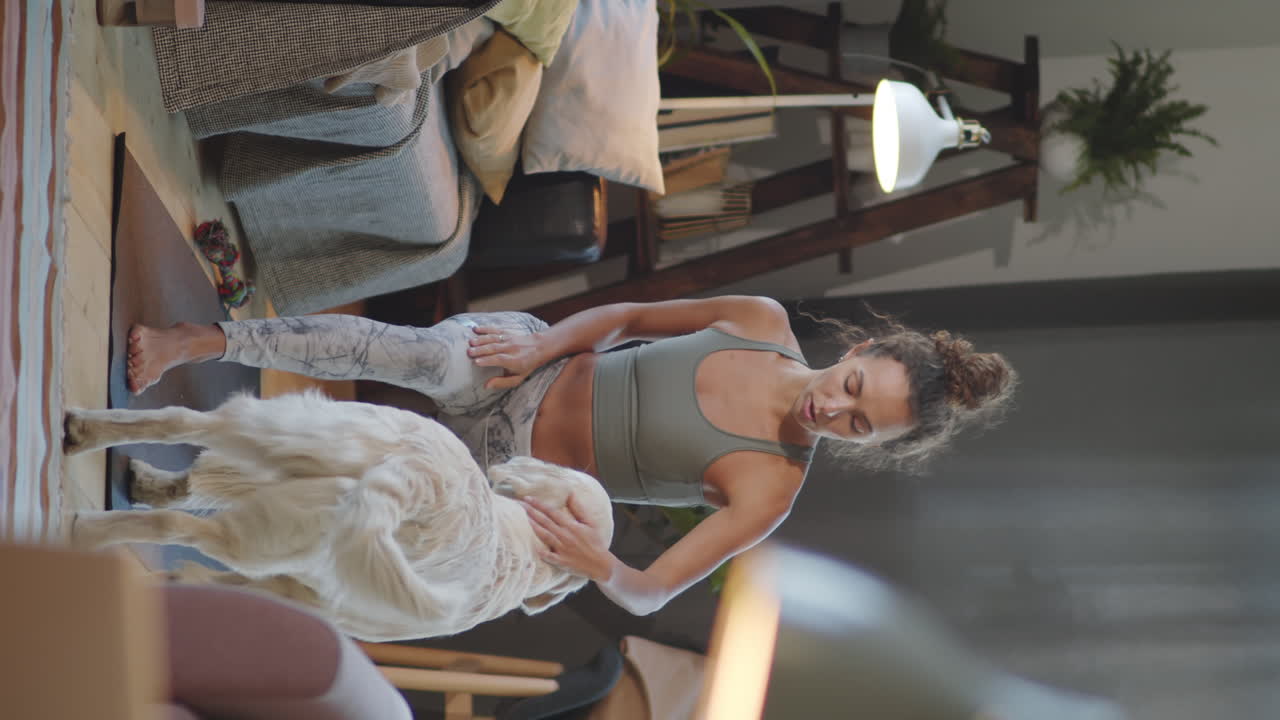 집 에서 개 와 함께 요가 를 연습 하는 여자