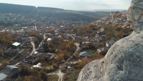 aerial view of a village nestled in a valley with mountains and rocks