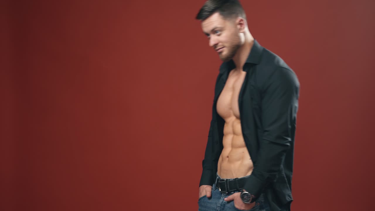 Muscular young man in studio. Strong muscular bodybuilder man with perfect trained body standing against background