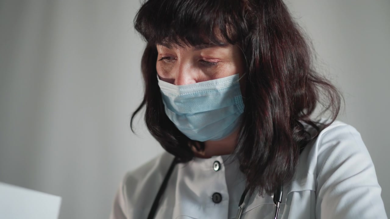 Il medico esamina il paziente. Lo specialista medico si concentra sulla documentazione del paziente con cura attenta. L'operatore sanitario caucasico esamina accuratamente le cartelle cliniche sotto illuminazione interna controllata