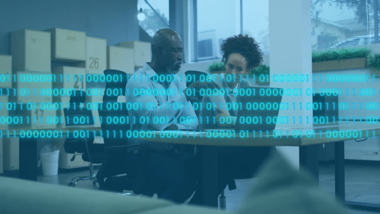 Binary code animation over two people collaborating at office desk