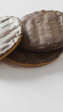 video of three chocolate coated biscuits on white background with copy space