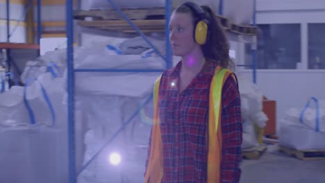 animation of glowing light over caucasian woman working in warehouse