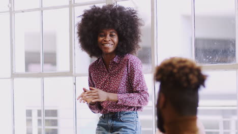 Una-Mujer-Negra-Milenaria-Se-Presenta-Ante-Colegas-Creativos-En-Una-Sala-De-Reuniones,-Enfoque-Selectivo