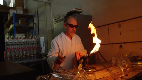 Front-view-of-mature-male-worker-lighting-glass-blowing-torch-in-glass-factory-4k